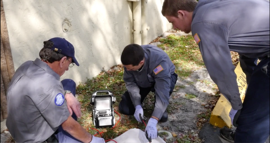 Plumbers inspecting drain lines at a South Florida home